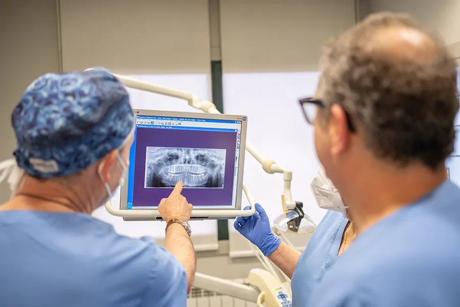 Dos profesionales de Clínicas Dentales Hernández Vallejo revisando una radiografía panorámica en el gabinete