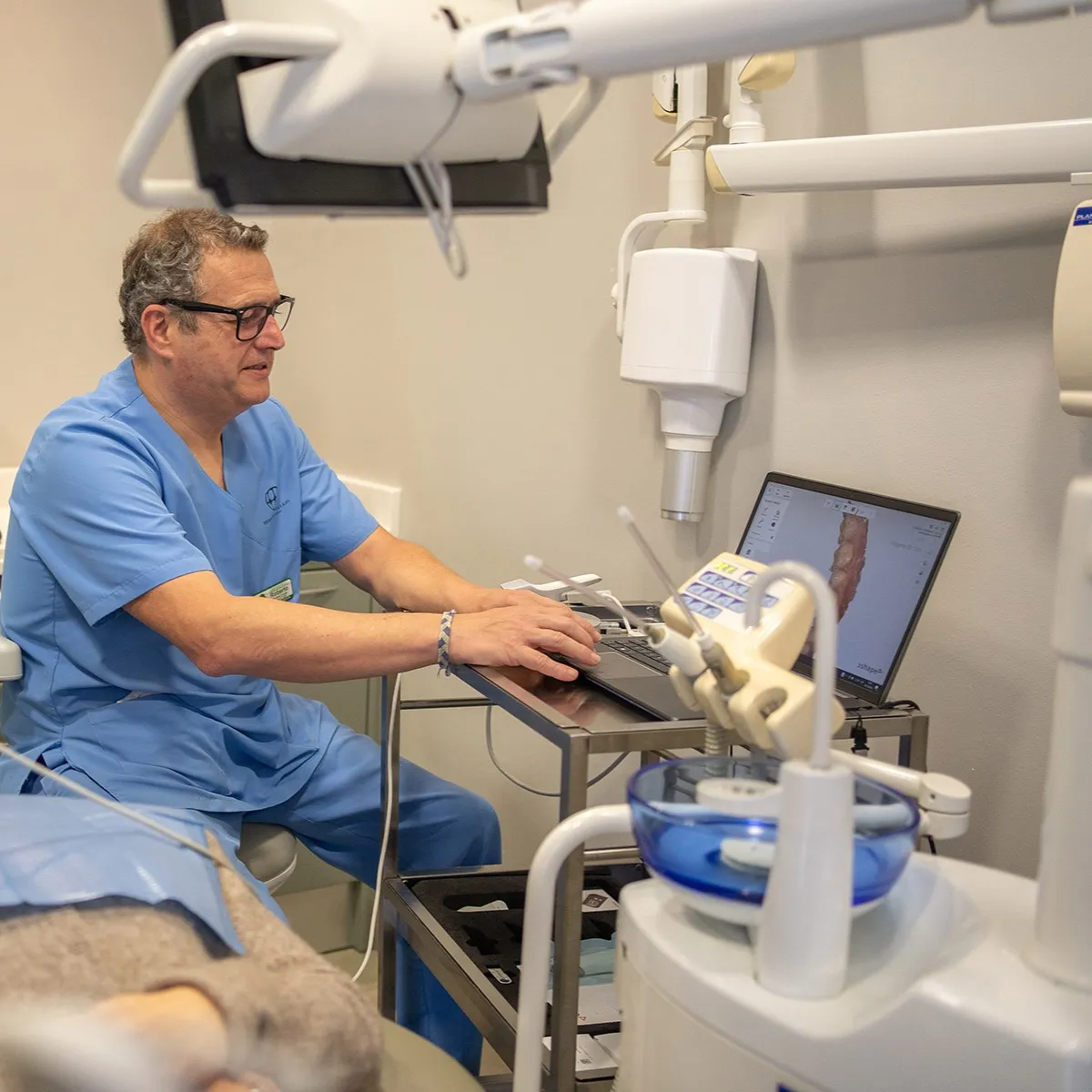 Doctor de Clínicas Dentales Hernández Vallejo revisando un escaneado intraoral en el portátil